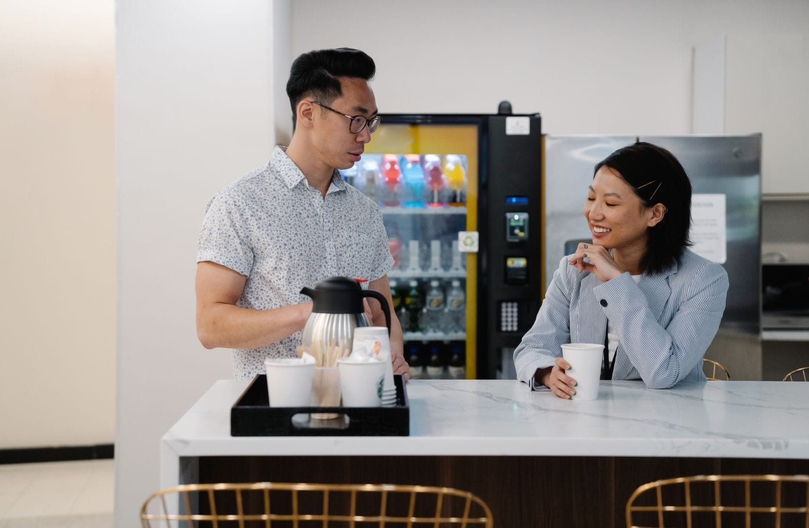 Employees at a breakroom counter beside a Silver Star serviced vending machine